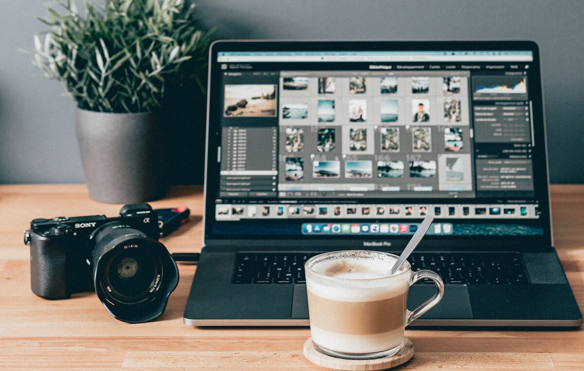 black laptop computer beside white ceramic mug on brown wooden table