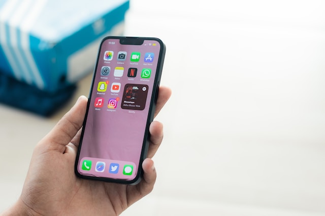 A hand holding a cell phone Description automatically generated