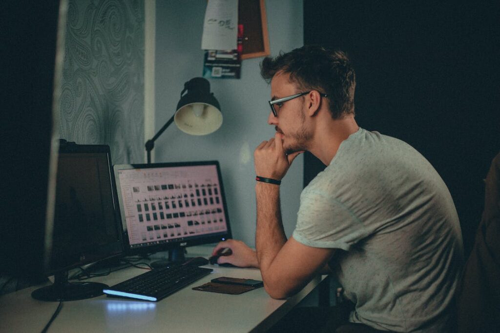 Free Man Using Computer Sitting on Chair Stock Photo