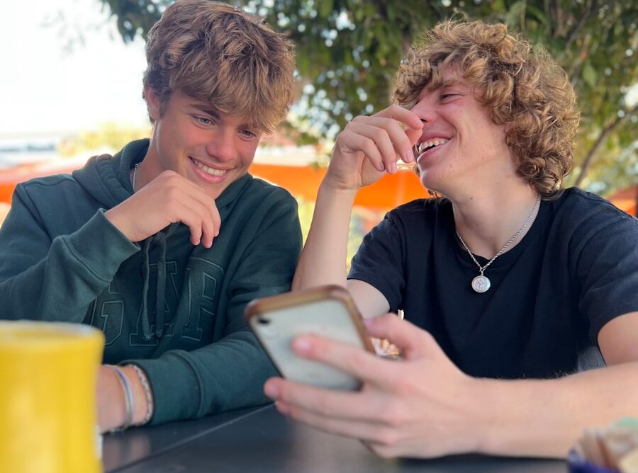 two people sitting at a table with a tablet