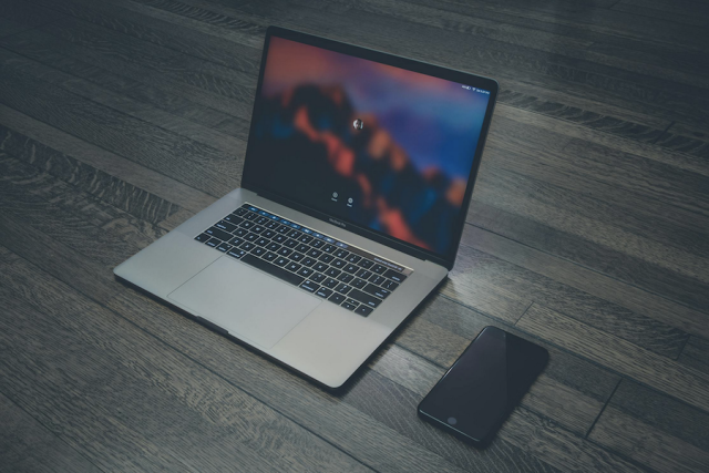 A computer and a phone on a wood floor AI-generated content may be incorrect.
