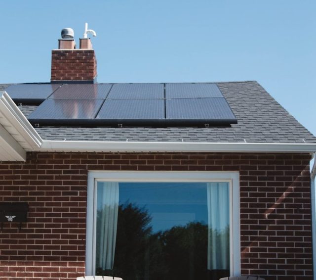 brown brick house with solar panels on roof